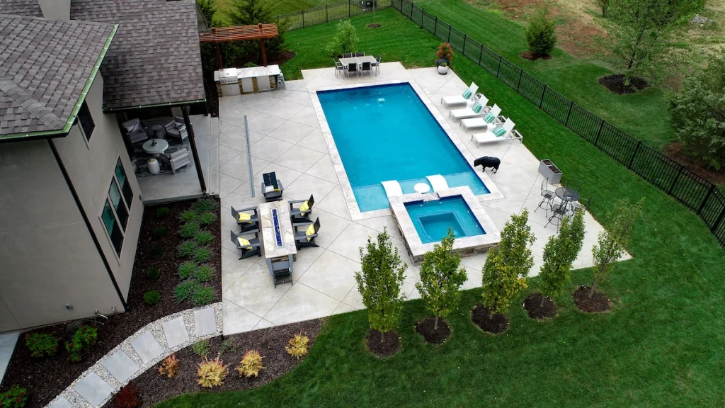 Aerial view of a residential backyard with an in-ground pool and dining set.