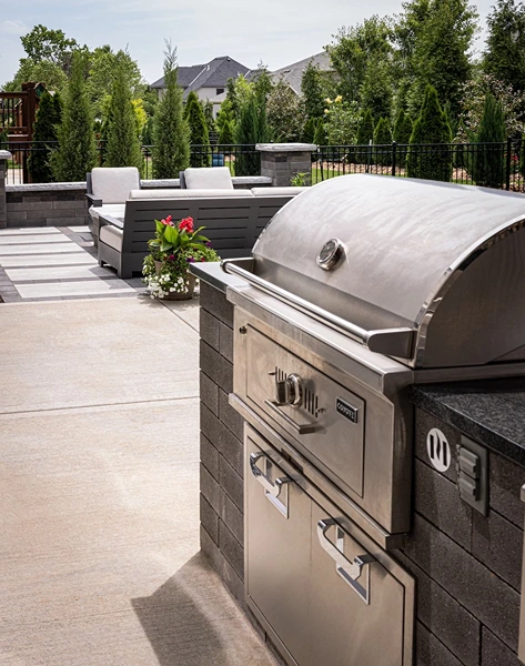 Angled view of a bbq and backyard landscaping.