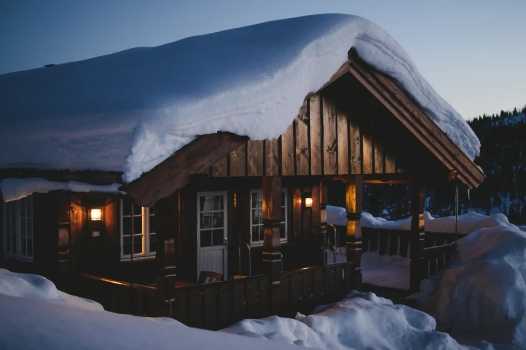 Brown wooden house during snow.